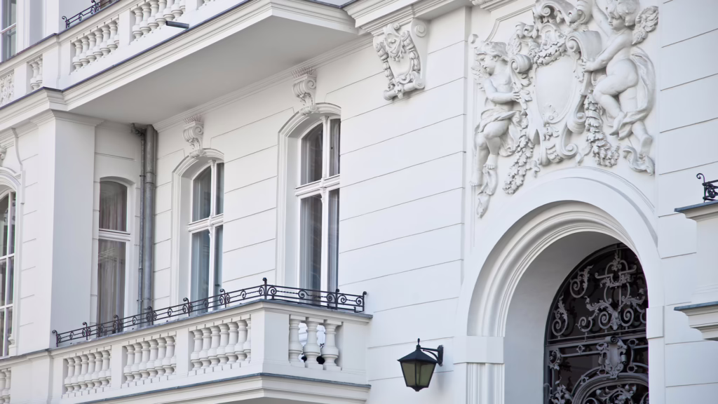 Das Bild zeigt ein Foto von einer weißen Hausfassade im barocken Stil.
